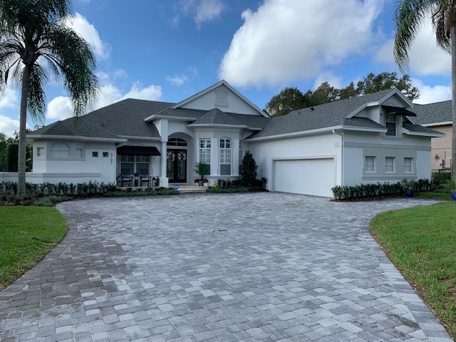 Wide paver driveway with a sweeping curve, cleaned and sealed