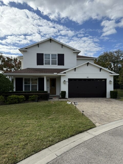 White two-story home with black shutters after repaint