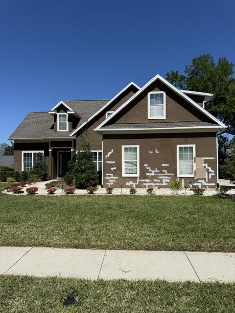 Home exterior inspected and marked for repair before painting