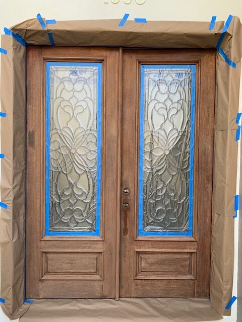 Mahogany double entry door masked off mid-refinish