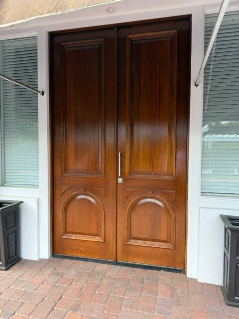 Travertine entry landing at a wood double door