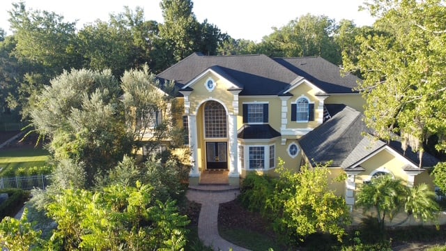 White stucco Florida home with a paver driveway after a full exterior repaint
